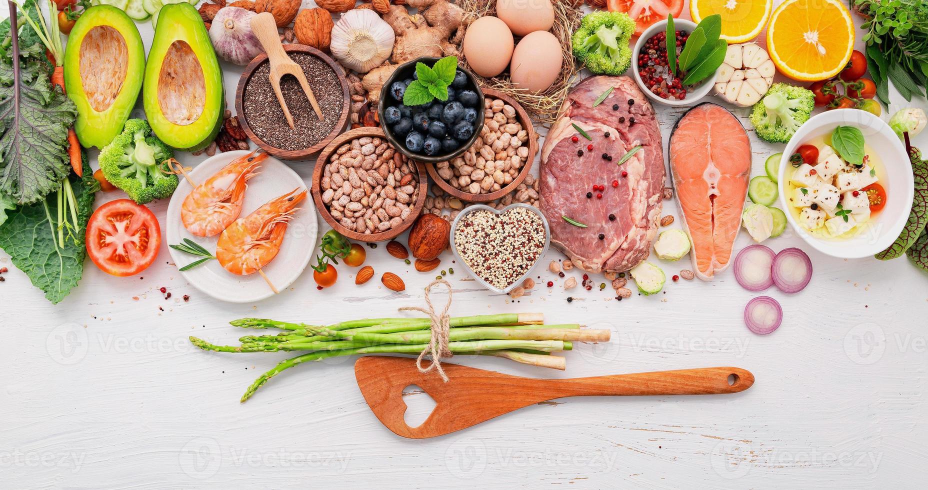 concepto de dieta cetogénica baja en carbohidratos. ingredientes para la selección de alimentos saludables sobre fondo blanco de madera. foto