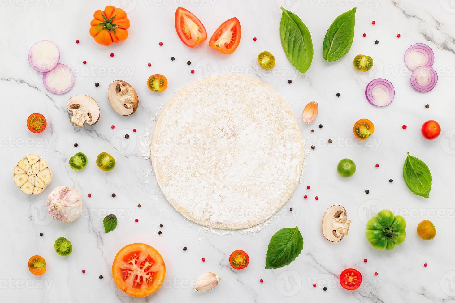 The ingredients for homemade pizza set up on white marble background. photo