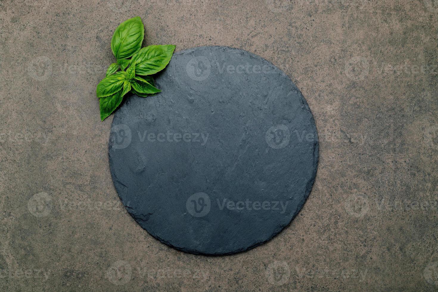 Empty pizza platter for homemade baking set up on dark concrete. Food recipe concept on dark stone background texture with copy space. photo