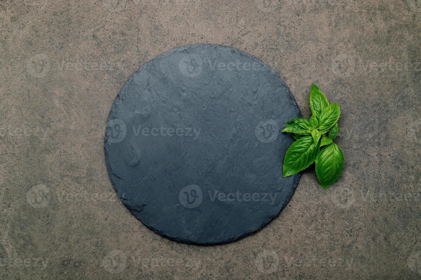 Empty pizza platter for homemade baking set up on dark concrete. Food recipe concept on dark stone background texture with copy space. photo