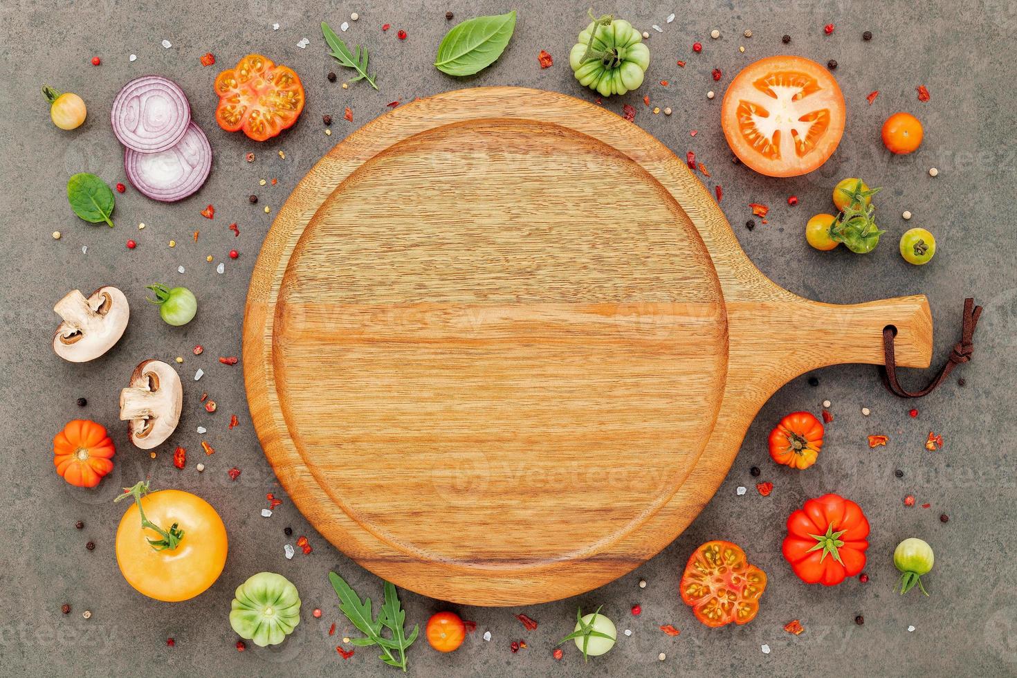 The ingredients for homemade pizza set up on dark stone background. photo