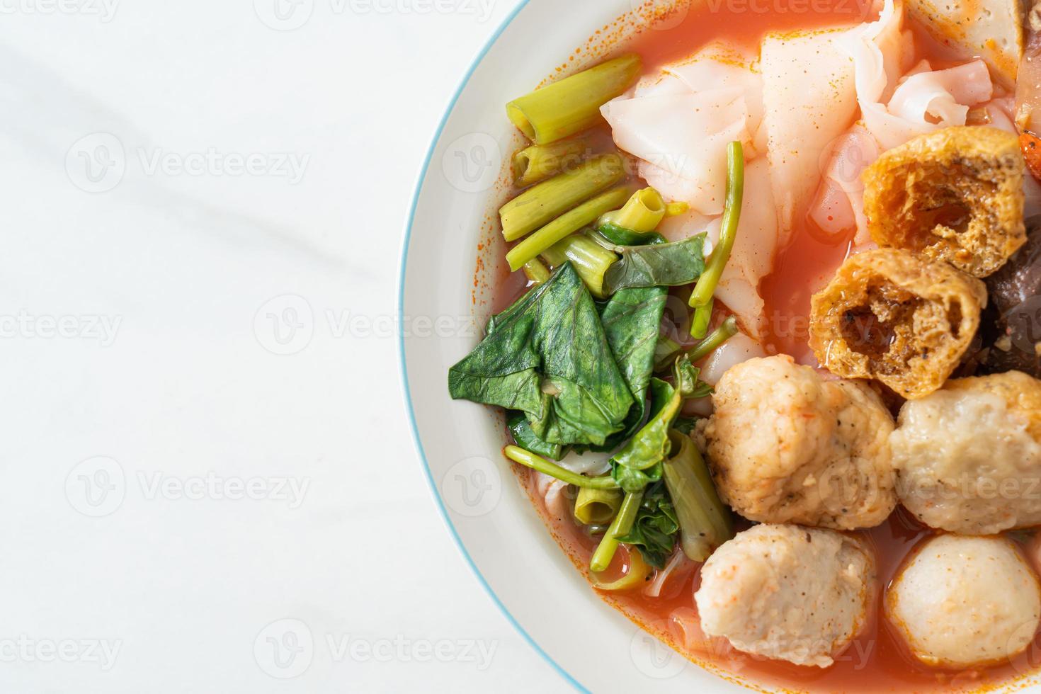 noodles with meatballs in pink soup photo