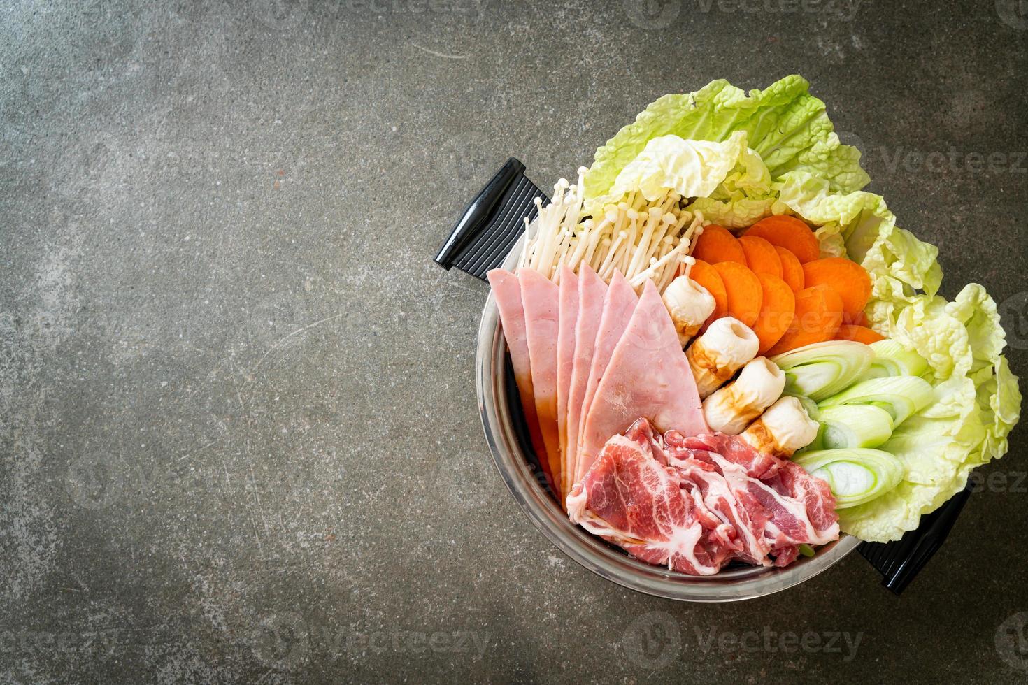 sukiyaki o shabu sopa negra de olla caliente con carne cruda y verdura foto