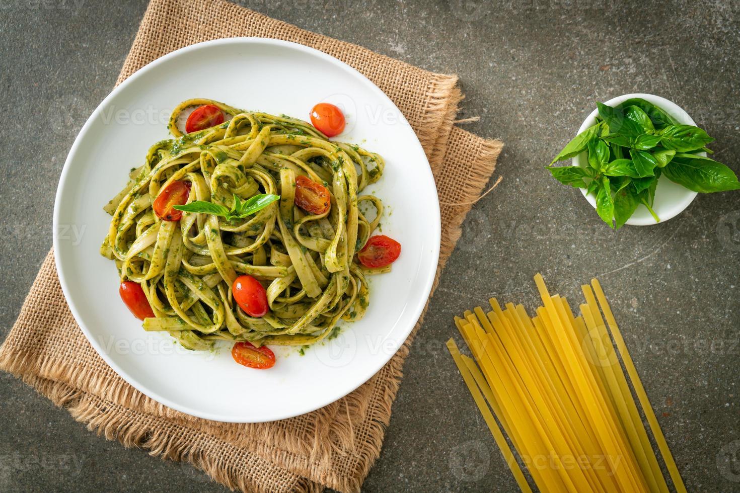 espaguetis fettuccine con salsa pesto y tomates foto