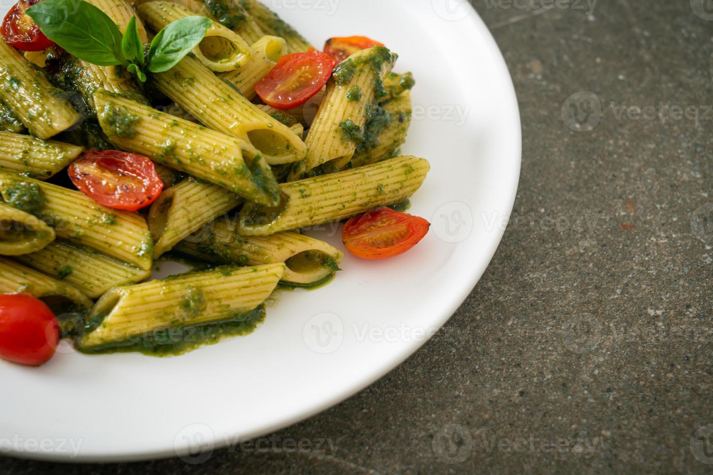 penne pasta with pesto sauce and tomatoes photo