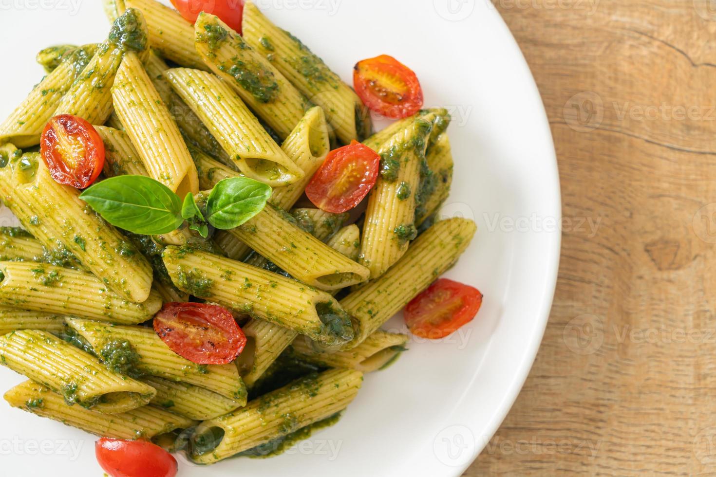 pasta penne con salsa pesto y tomates foto