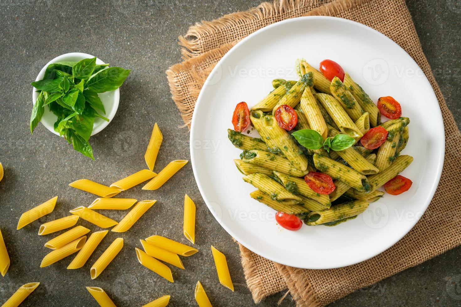 pasta penne con salsa pesto y tomates foto