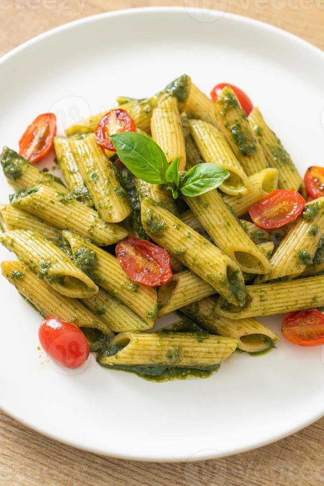 pasta penne con salsa pesto y tomates foto