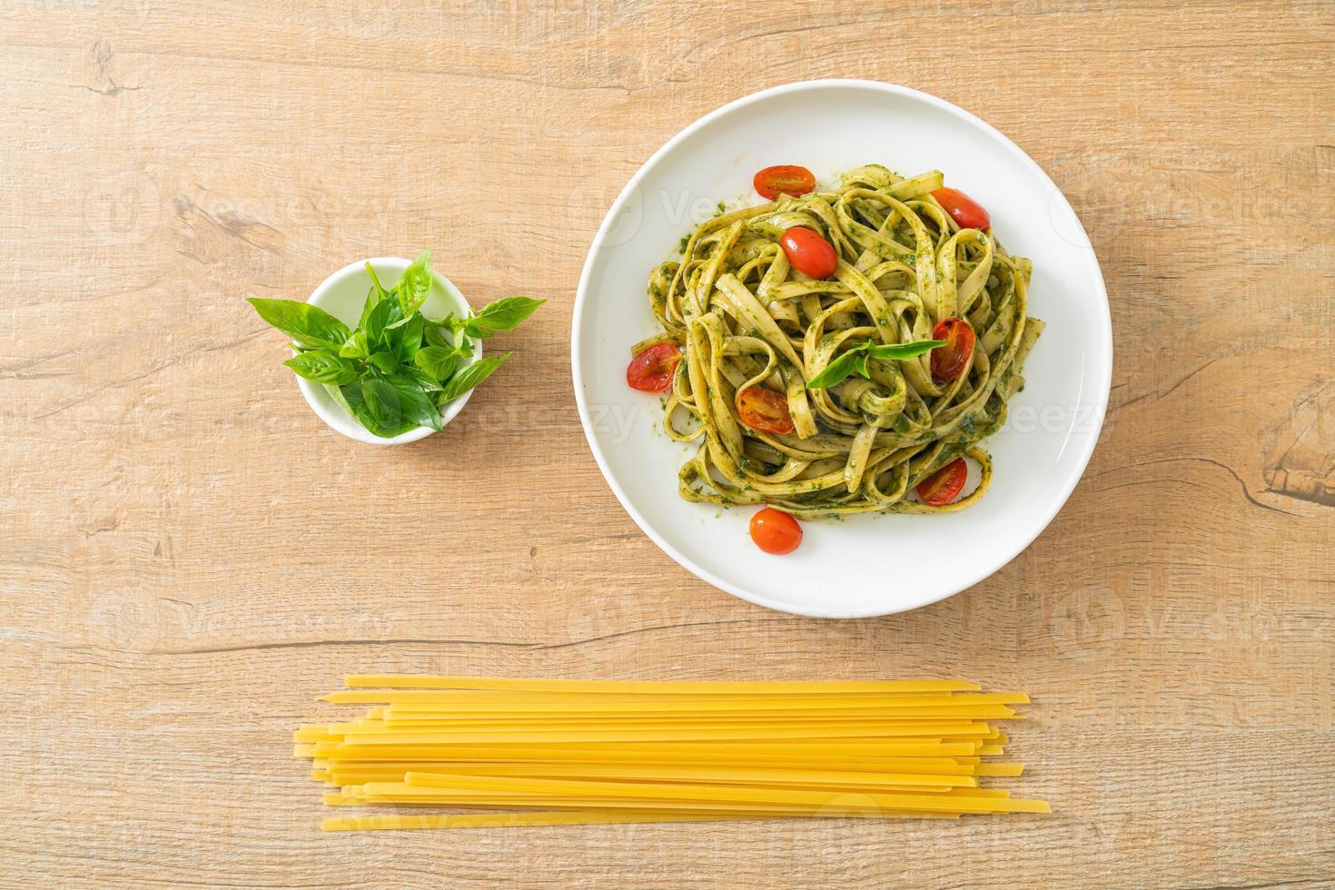 espaguetis fettuccine con salsa pesto y tomates foto