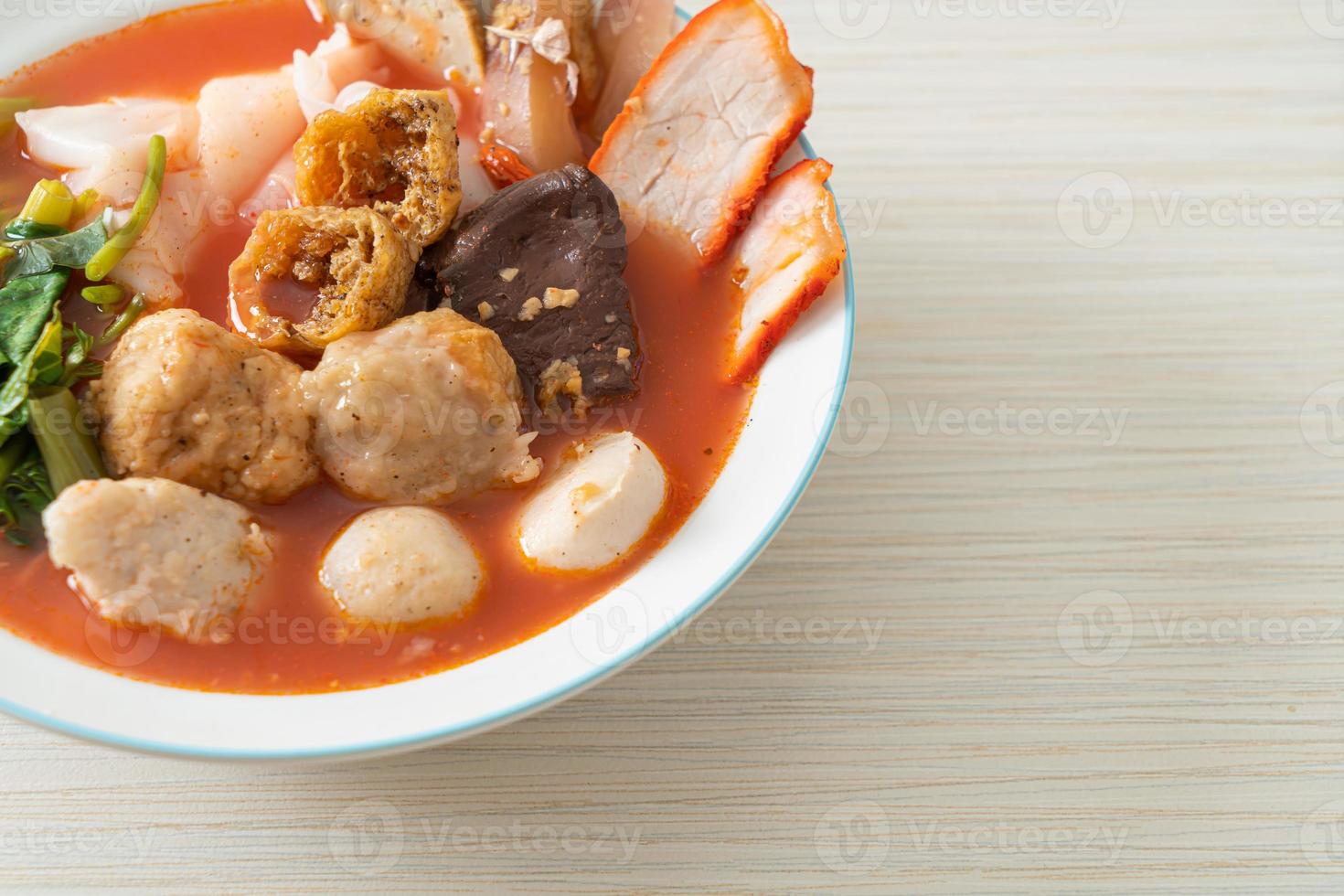 noodles with meatballs in pink soup photo