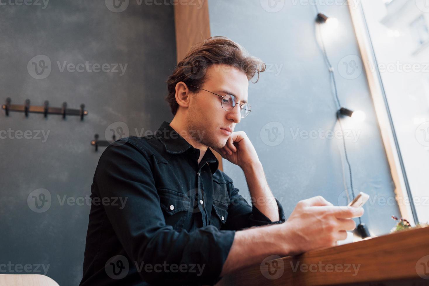 soft focus.man holding and using sell phone.while sitting and relax on sofa at modern house.concept for young people working mobile device photo