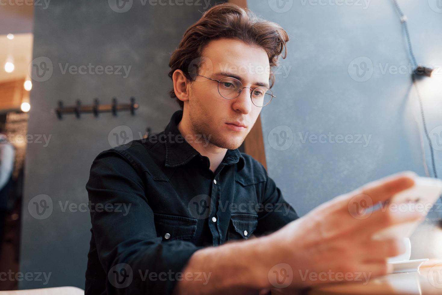 Close-up of man received good news on smart phone, Man resting in cafe and texting new mail messages, blurred background, shallow DOF photo