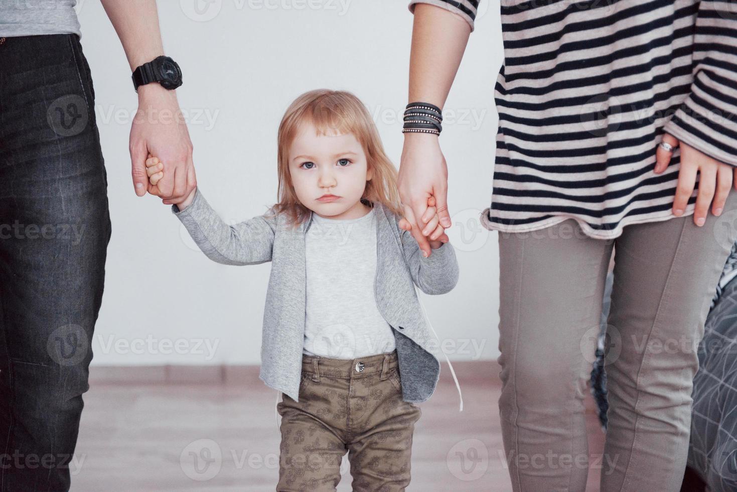 familia feliz se está divirtiendo en casa. madre, padre e hija pequeña con peluche disfrutan de estar juntos foto