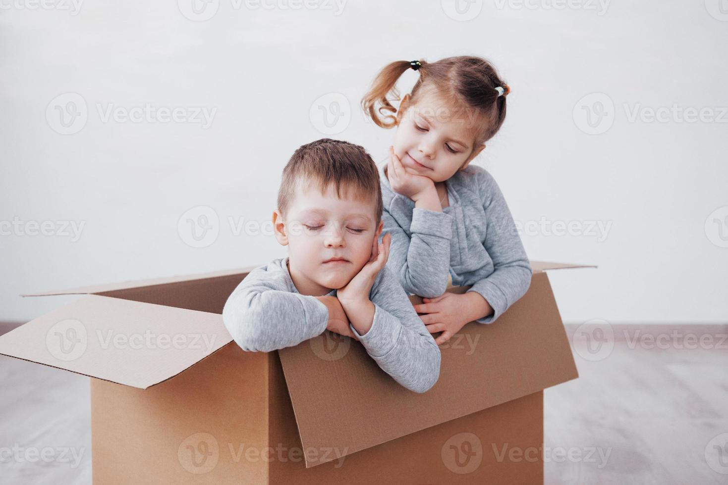 dos niños pequeños, niño y niña, se acaban de mudar a una nueva casa. foto del concepto .. los niños se divierten.