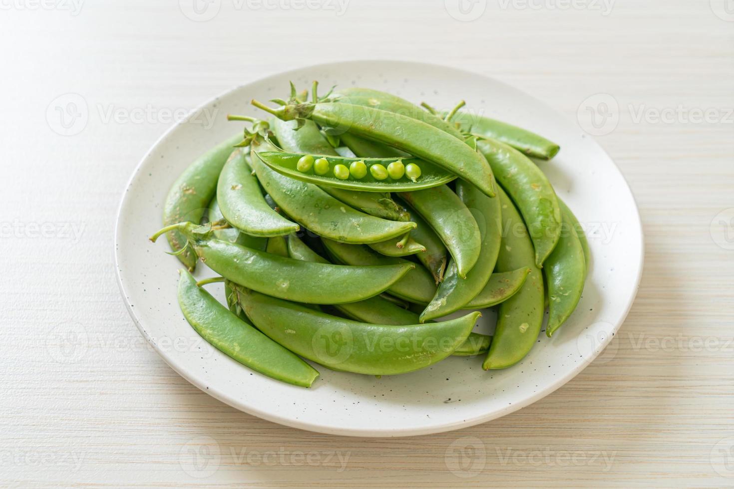 guisantes verdes dulces frescos en un plato foto
