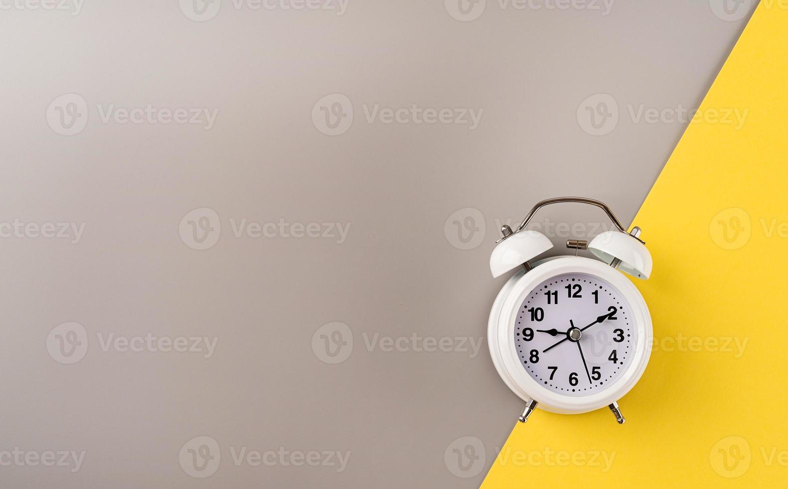 White retro alarm clock isolated on double yellow and gray background with copy space photo