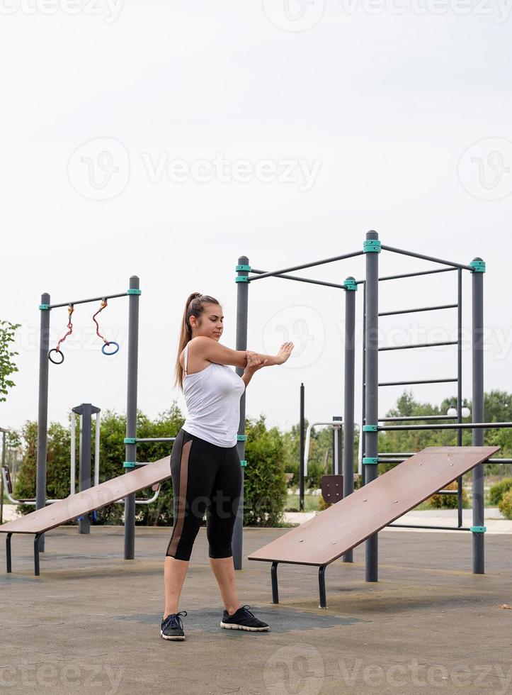 Happy woman working out on the sports ground in sunny summer day photo