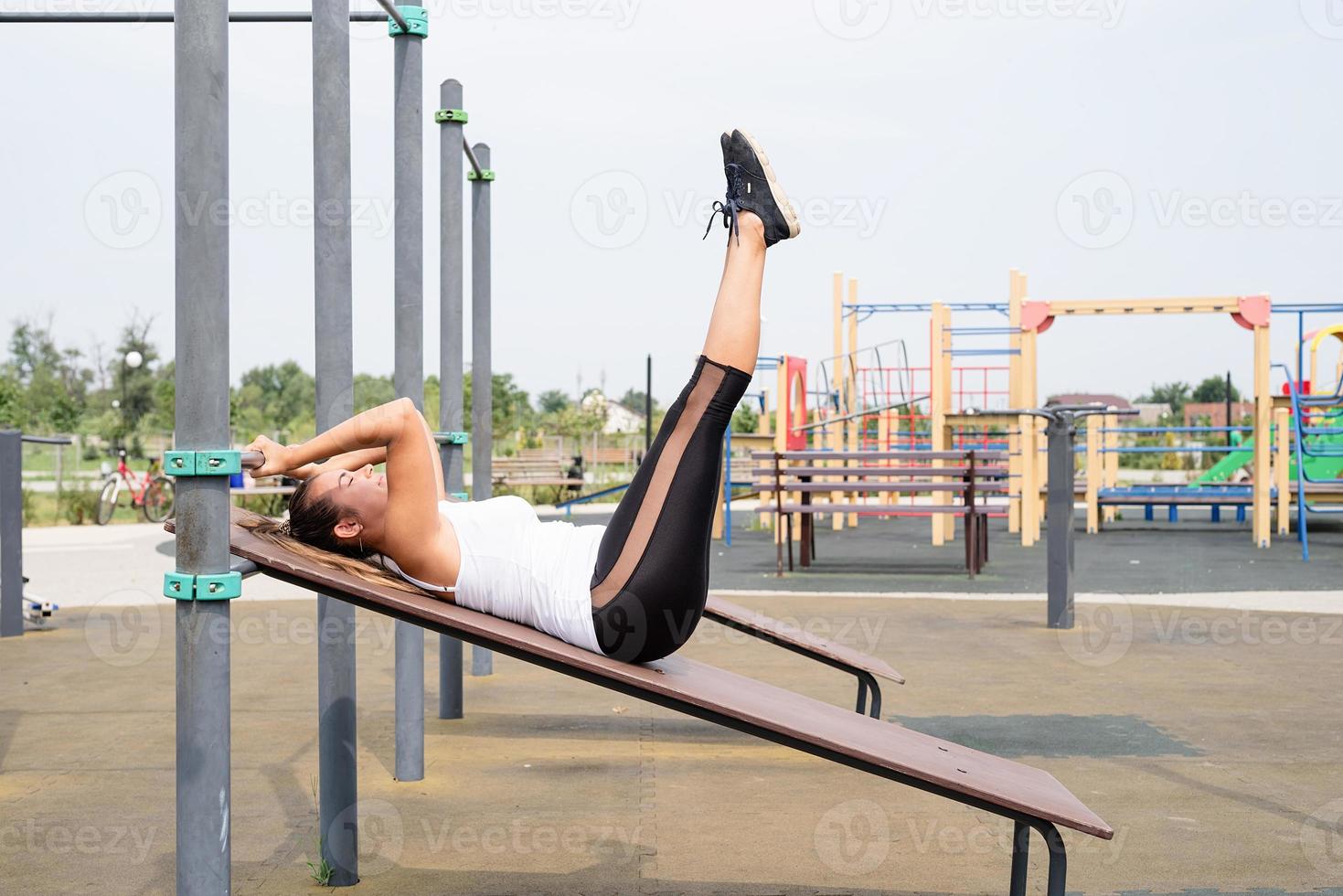 Happy woman working out on the sports ground in sunny summer day photo