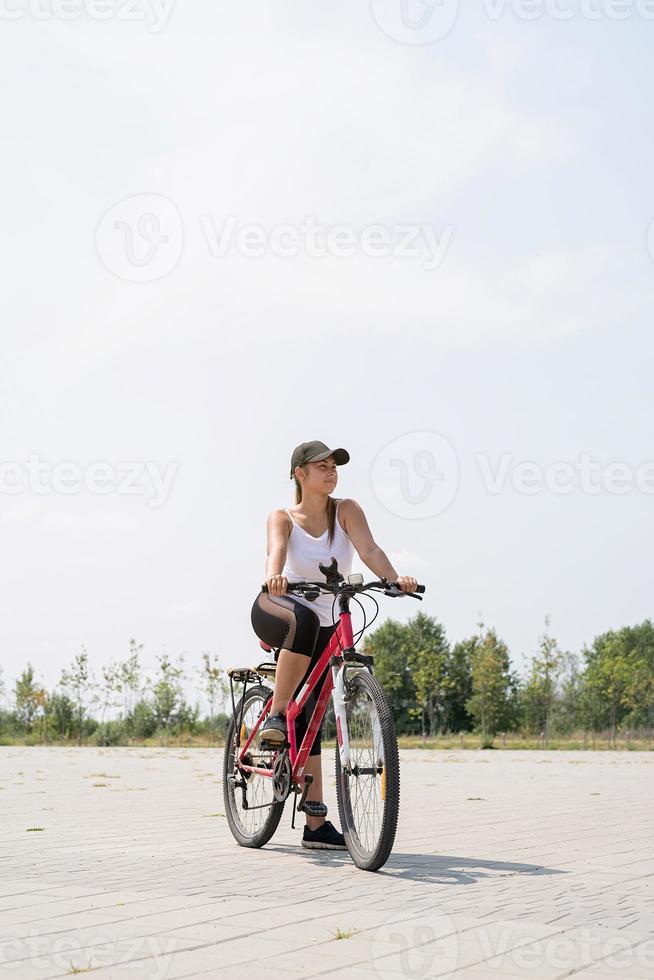 Carefree Woman riding a bike in a park photo