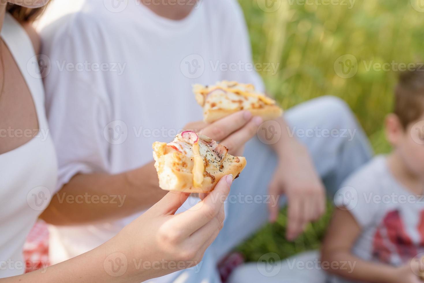 Pareja joven haciendo un picnic en el campo de girasol al atardecer foto