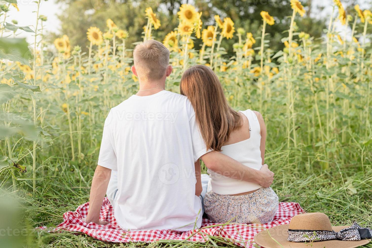 Young couple cuddling on a picnic blanket photo