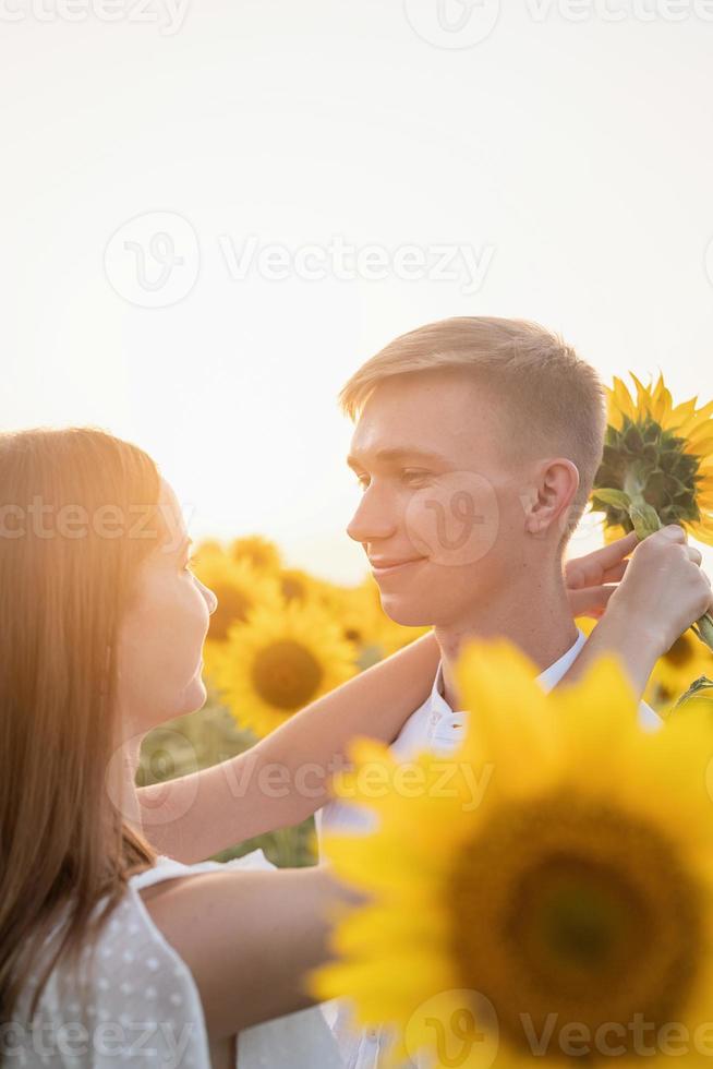 hermosa pareja divirtiéndose en campos de girasoles foto