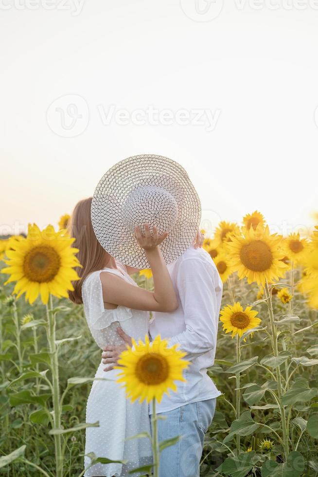 Beautiful couple having fun in sunflowers fields photo