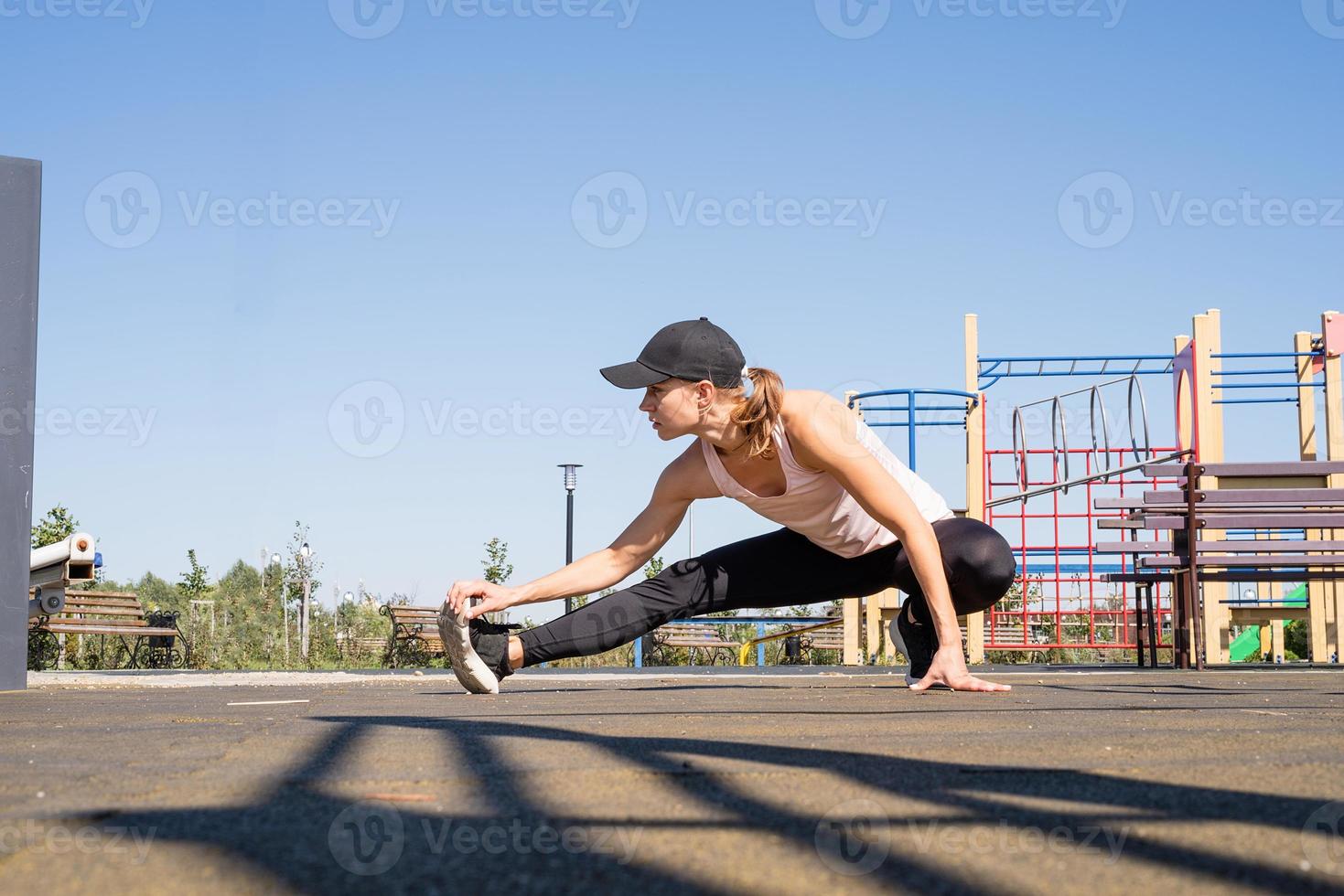 Sportive woman working out on the sports ground in sunny summer day photo