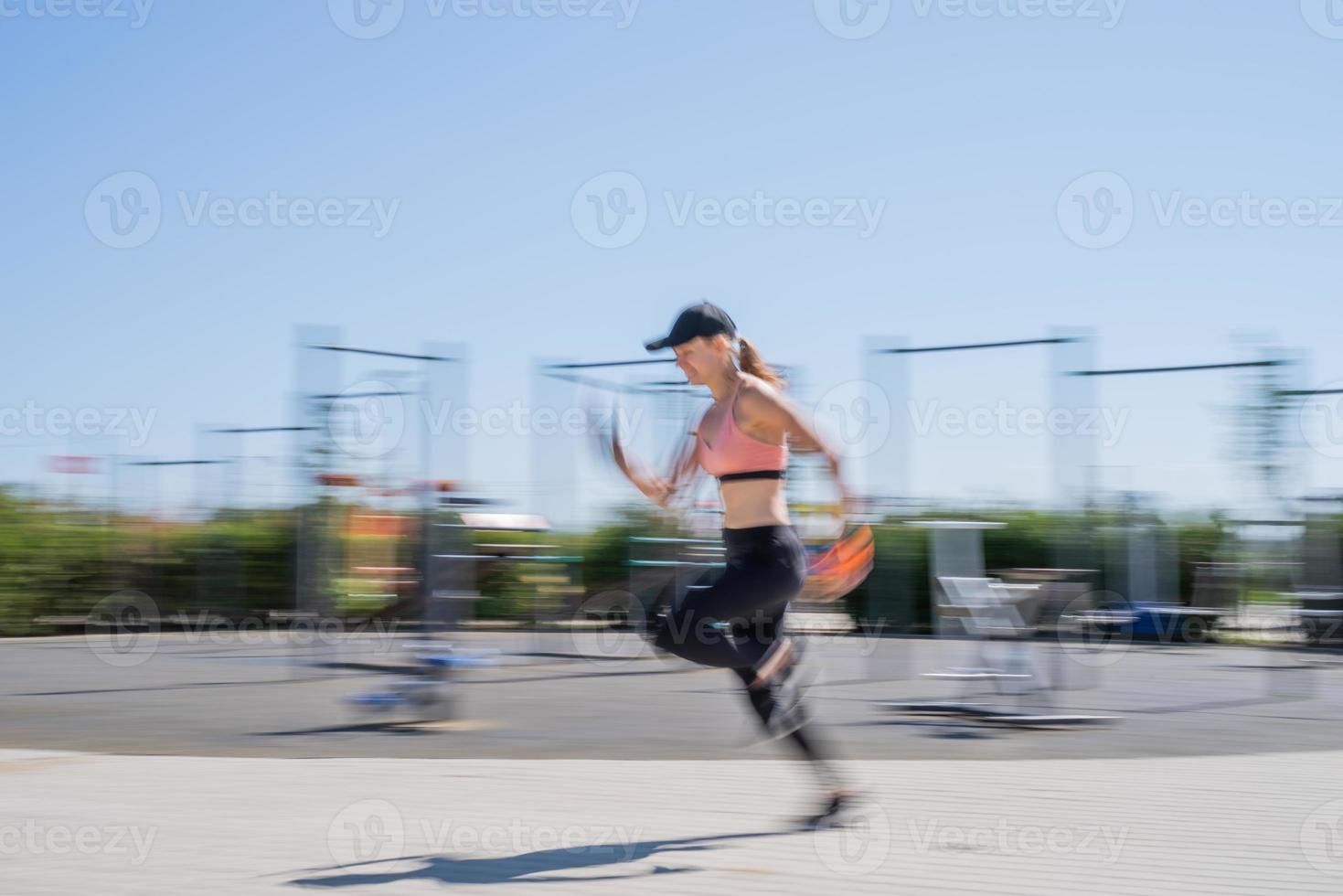 Sportive woman working out on the sports ground in sunny summer day photo