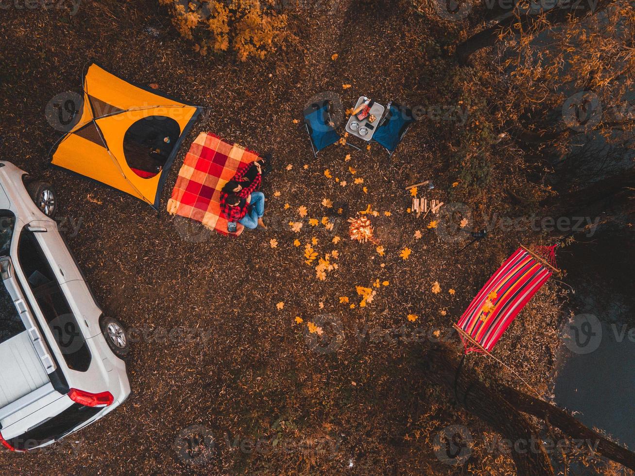 Overhead top view of autumn camping site with tent car hammock bonfire photo