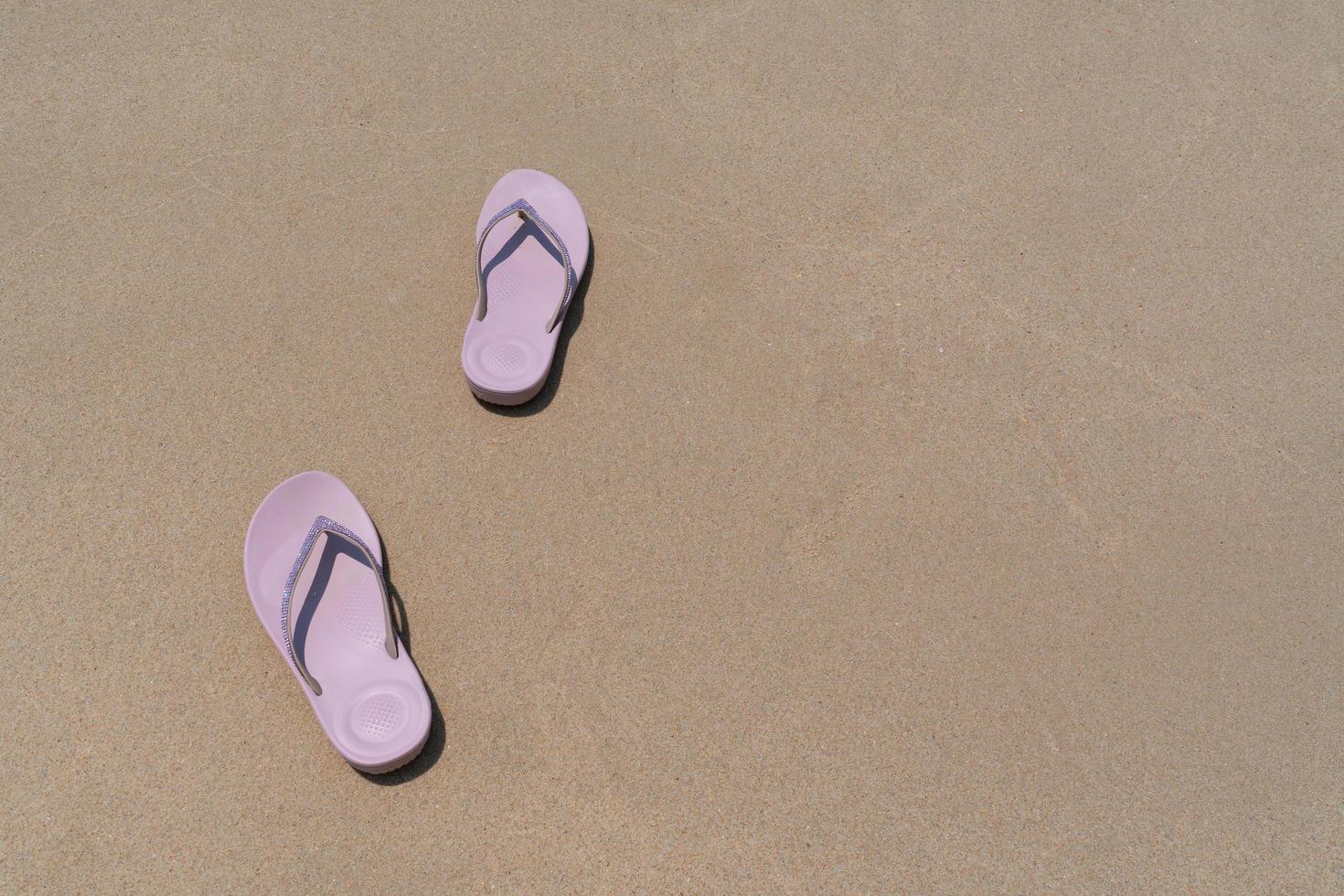 Pink beach walk slippers or sandles of young woman placing on white beach and blue sea on summer vacation. travel concept photo