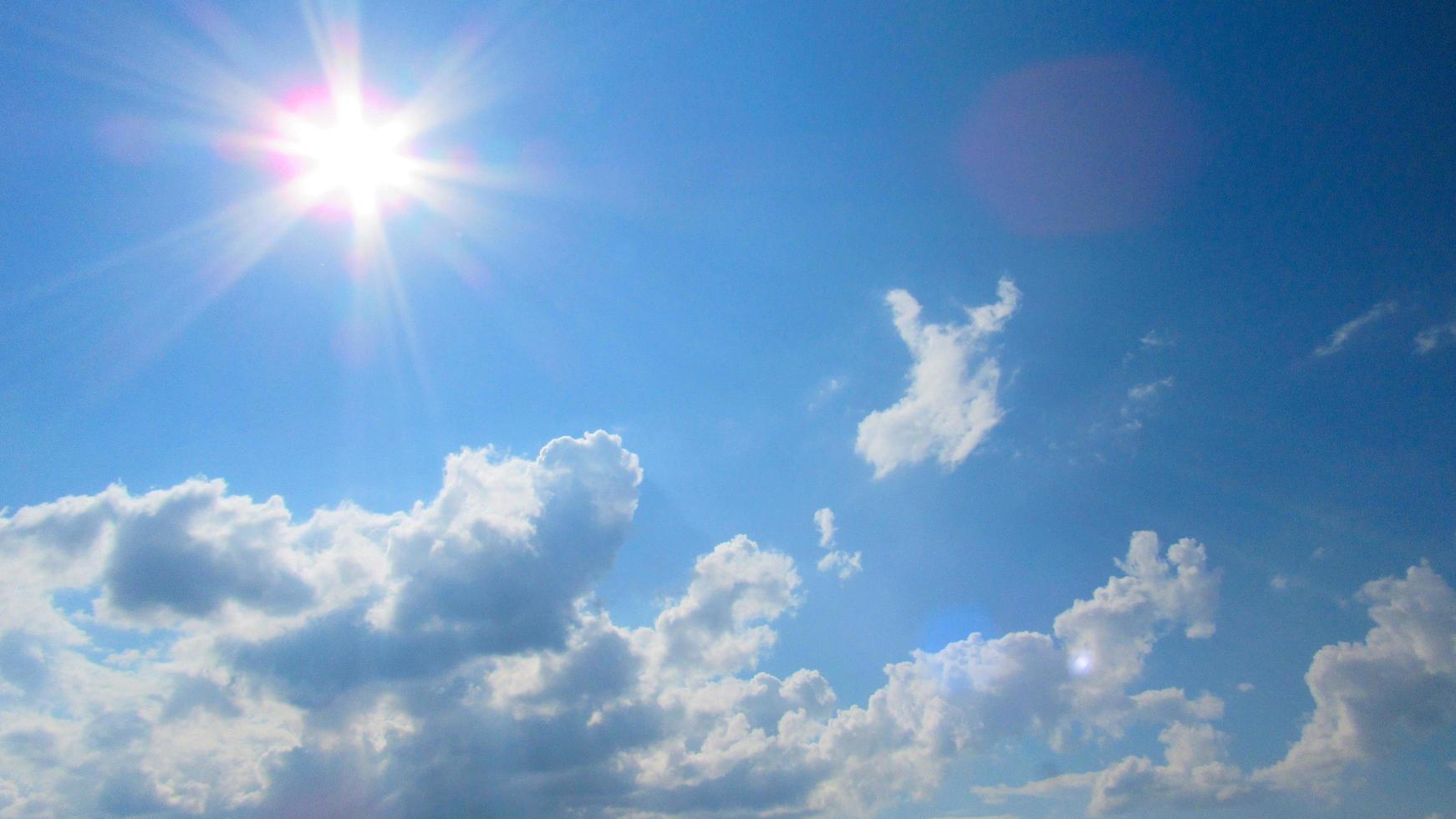 sol, cielo y nubes. sol en el fondo de un cielo azul con nubes blancas