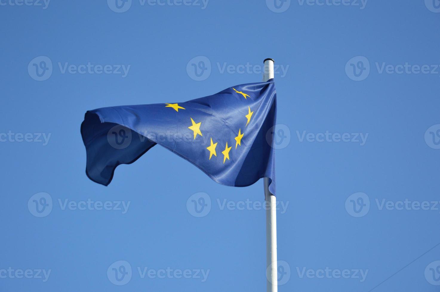 EU flag waving in the wind against a blue sky photo