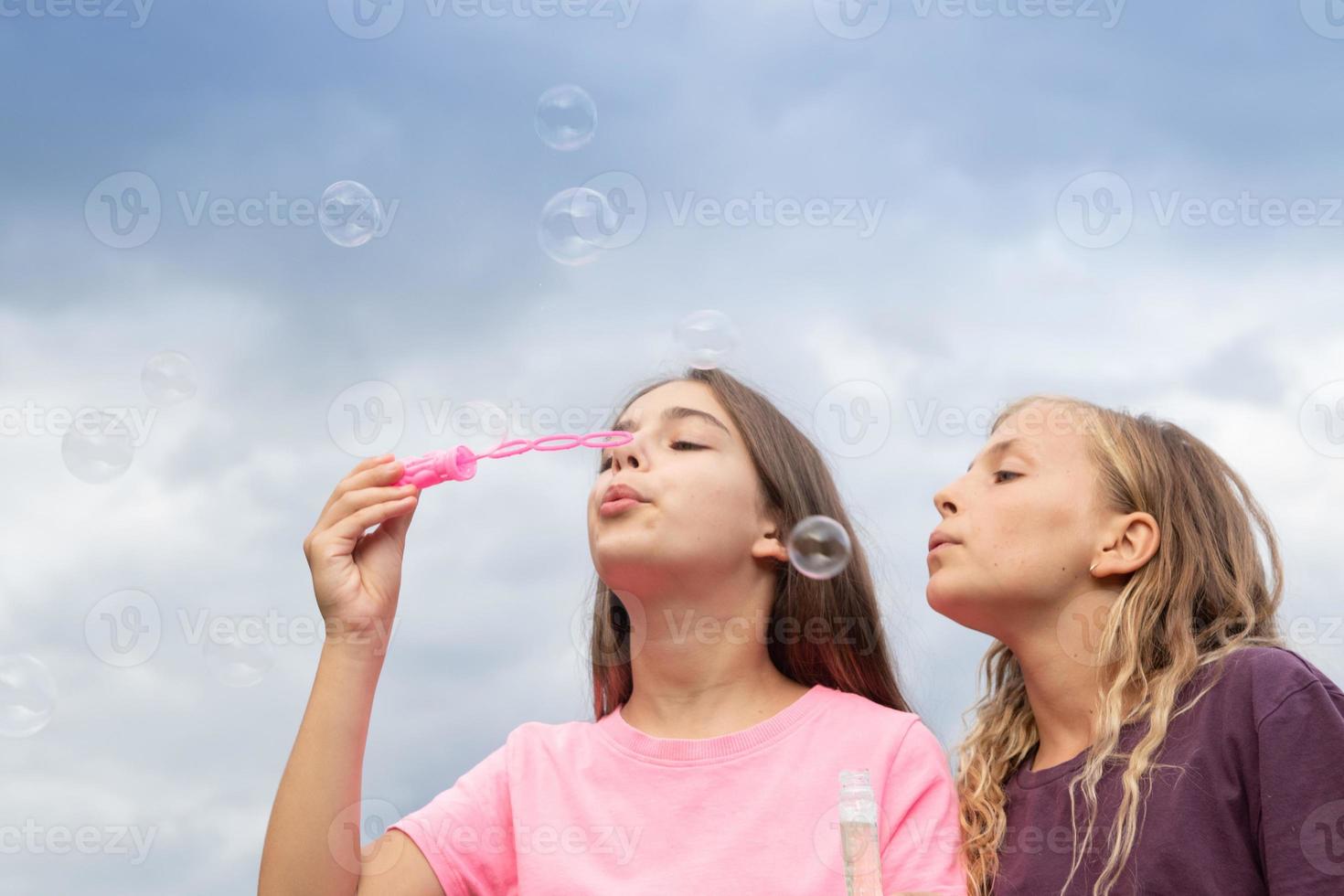 dos chicas haciendo pompas de jabón - tiempo libre y divertido y amistad foto