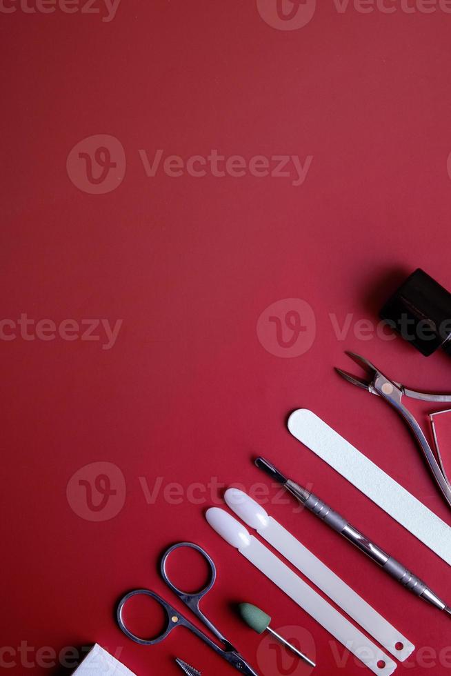 Manicure tools and tips on red background with copy space photo