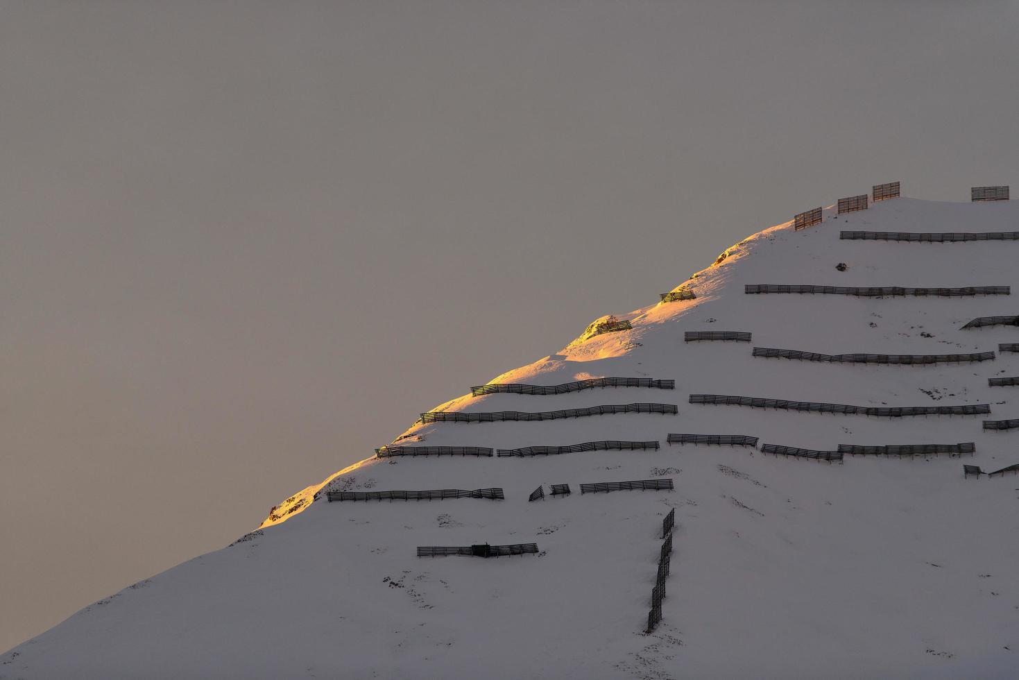 Avalanche barriers in the mountains at sunset photo