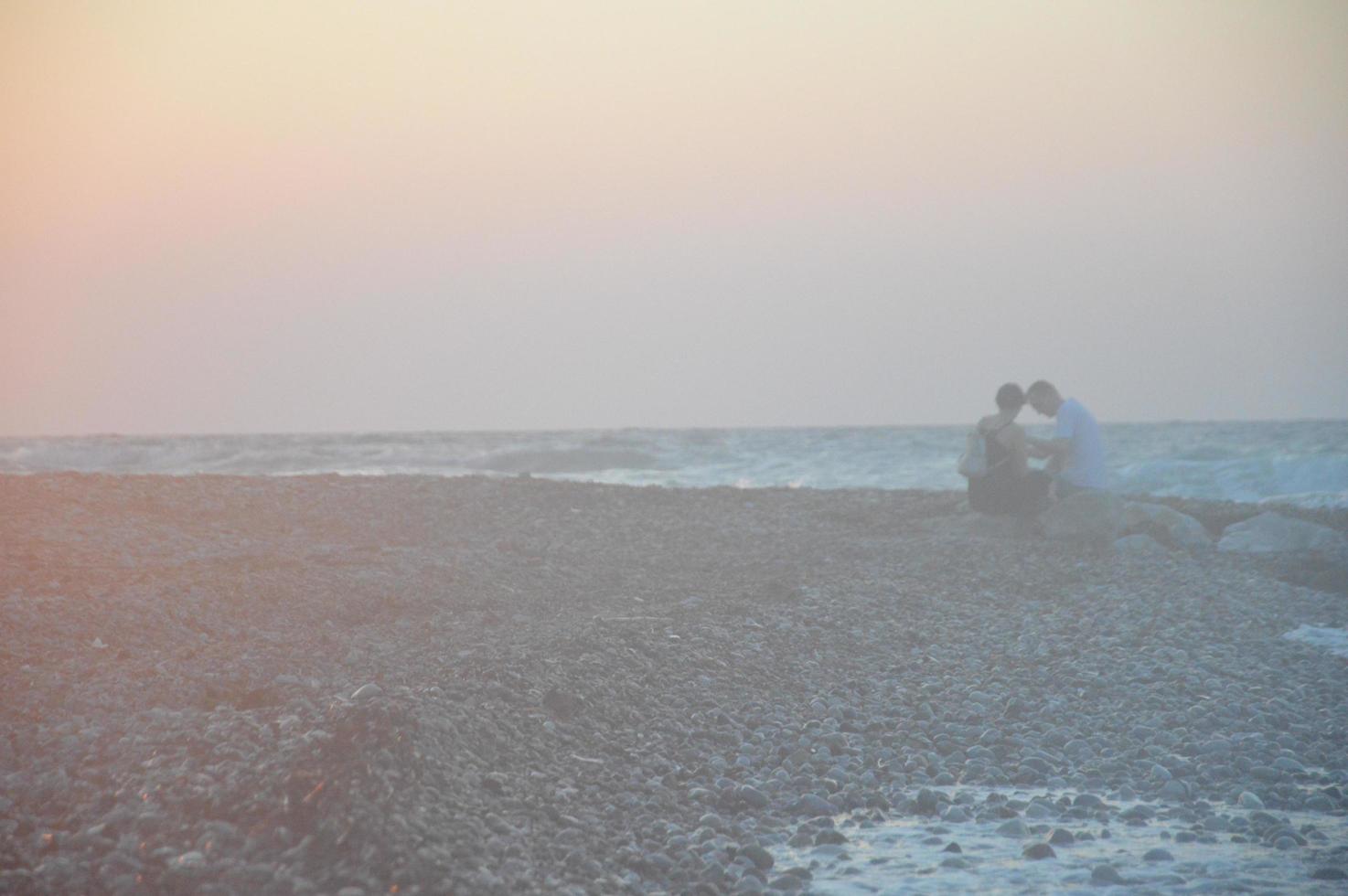 Young couple hugging at sunset on the Aegean sea in Greece photo