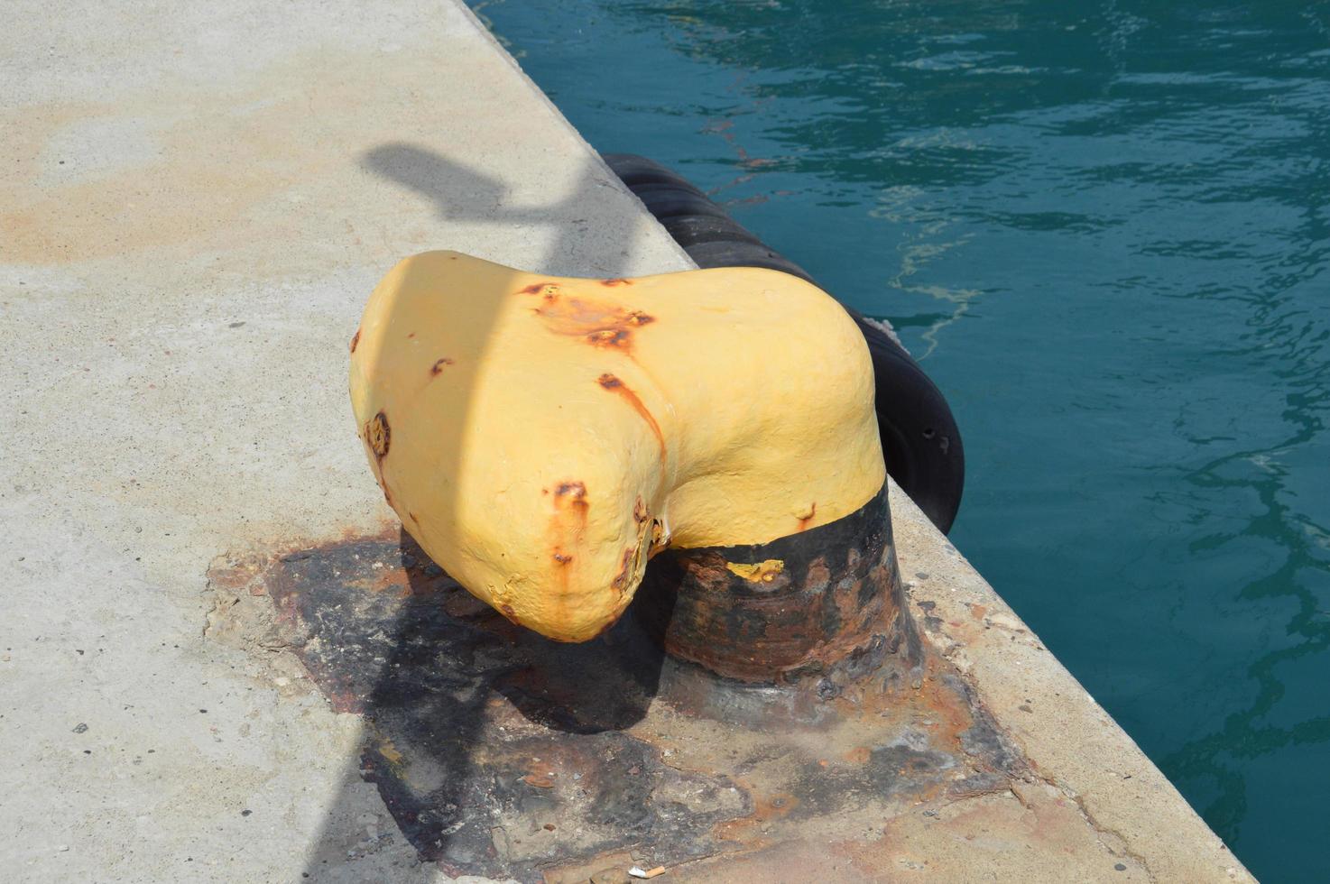 Bolardo de metal amarillo en el muelle foto