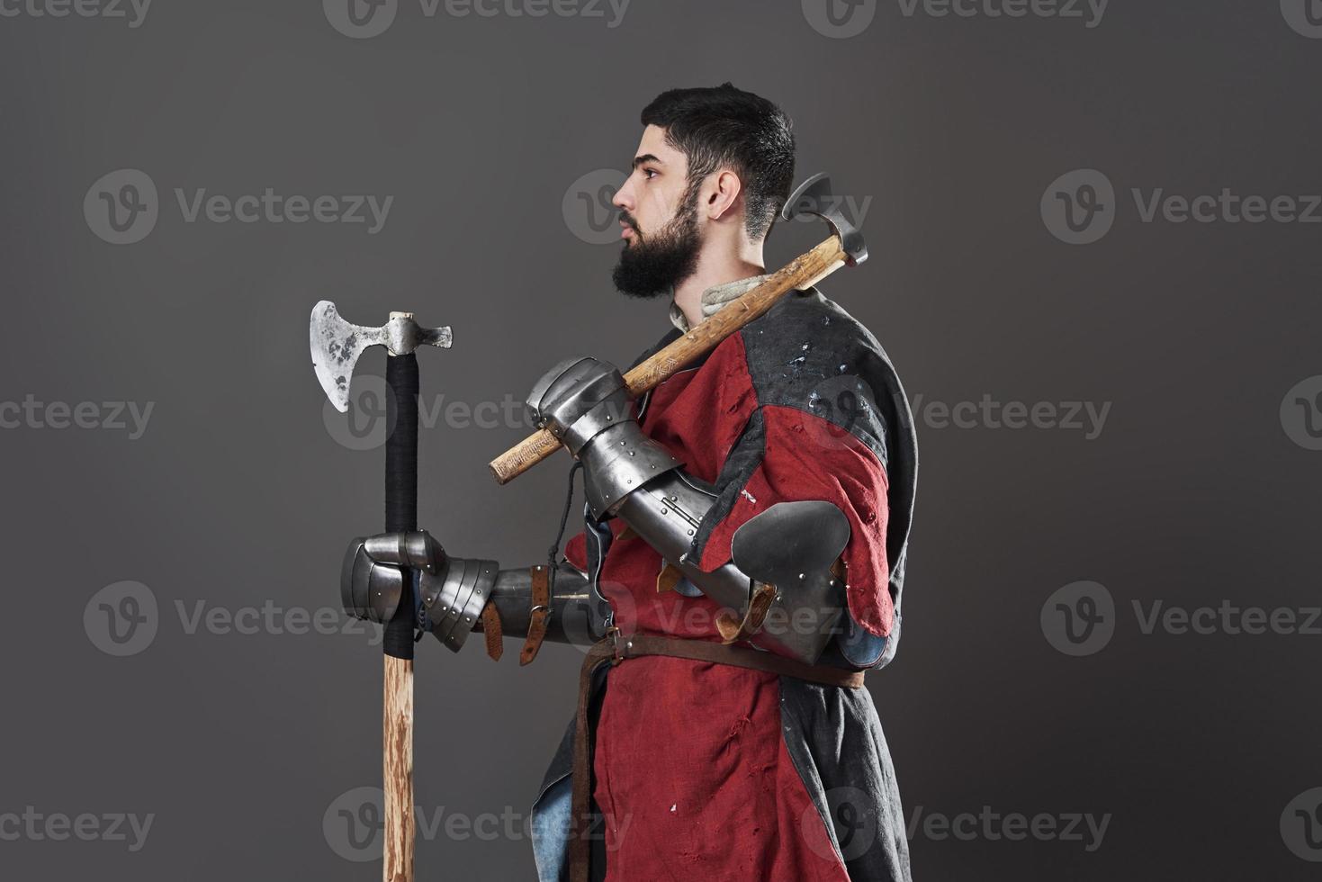 caballero medieval sobre fondo gris. retrato, de, brutal, cara sucia, guerrero, con, cota de malla, armadura, rojo, y, negro, ropa, y, batalla, hacha foto