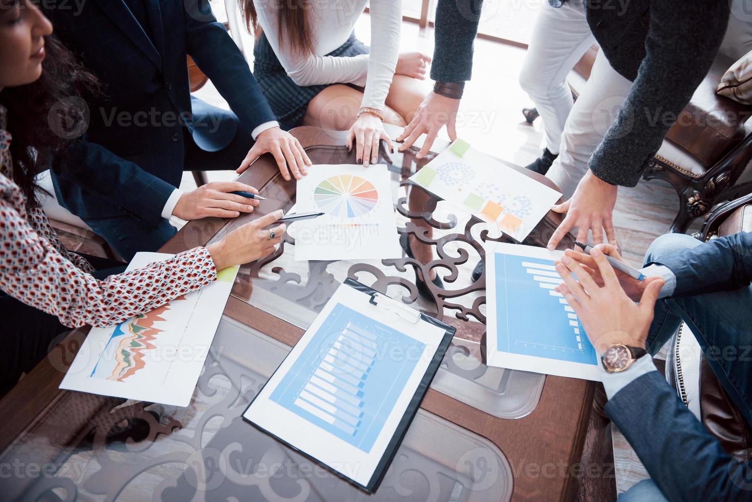 Business team brainstorming. Marketing plan researching. Paperwork on the table, laptop and mobile phone photo