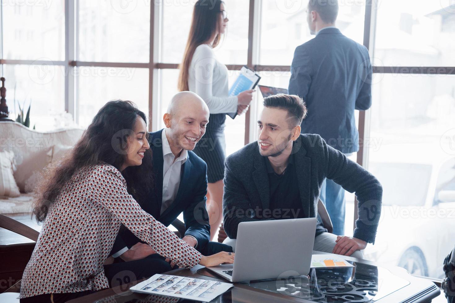 Young team of coworkers making great business discussion in modern coworking office. Teamwork people concept photo