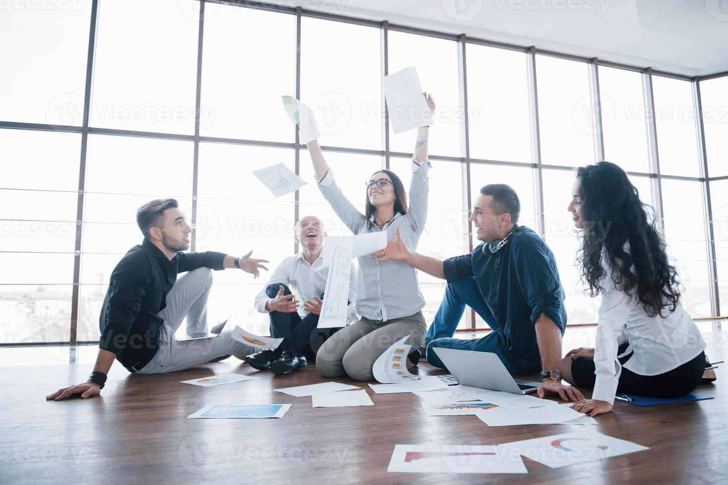 estrategia de éxito juntos. colegas de negocios alegres lanzando papeles en la oficina creativa. logro corporativo de cooperación. dibujo de diseño de planificación. concepto de trabajo en equipo foto