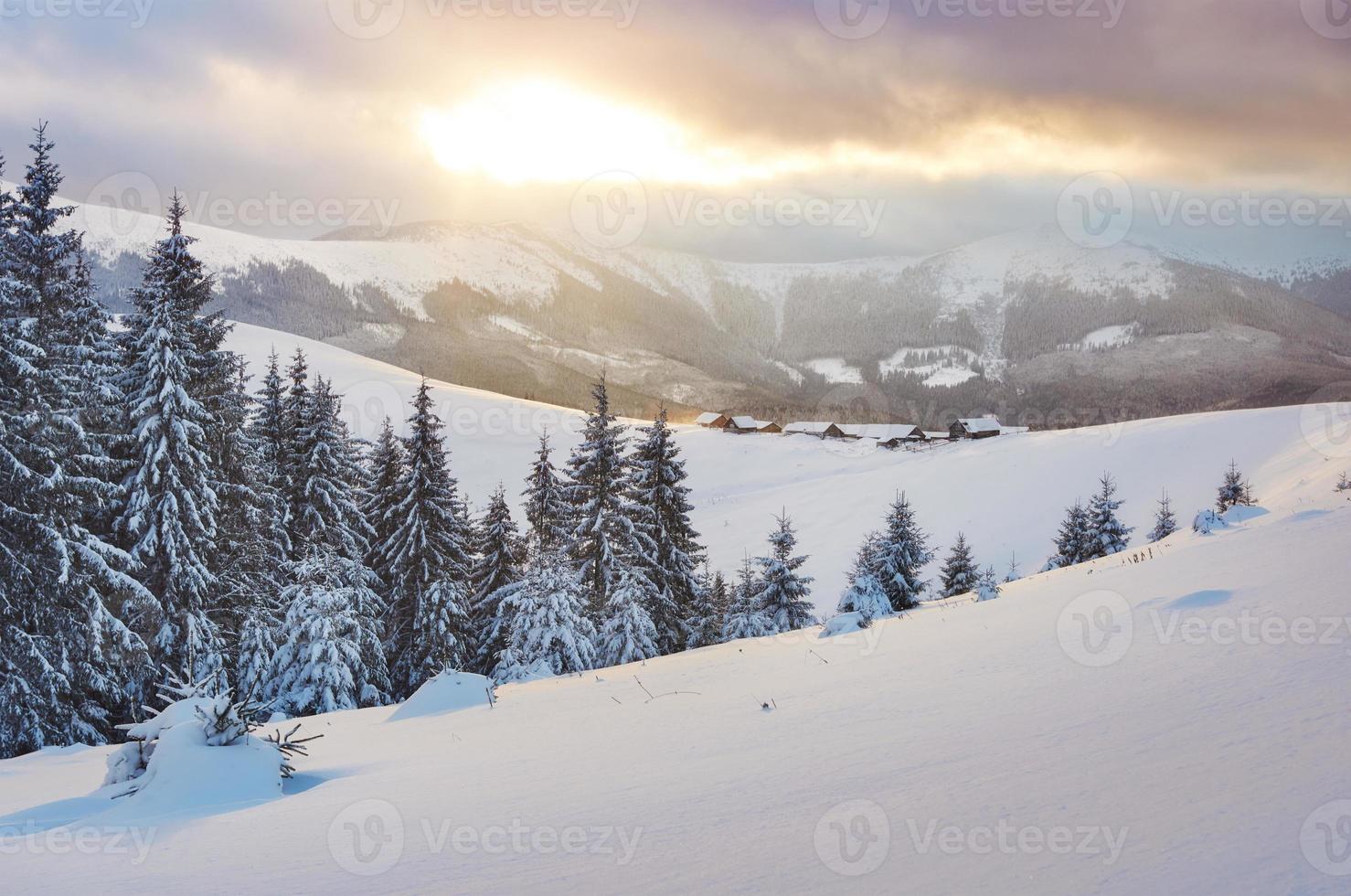 Majestic sunset at small village on a snowy hill under Ukrainian. Villages in the mountains in winter. Beautiful winter landscape. Carpathians, Ukraine, Europe photo