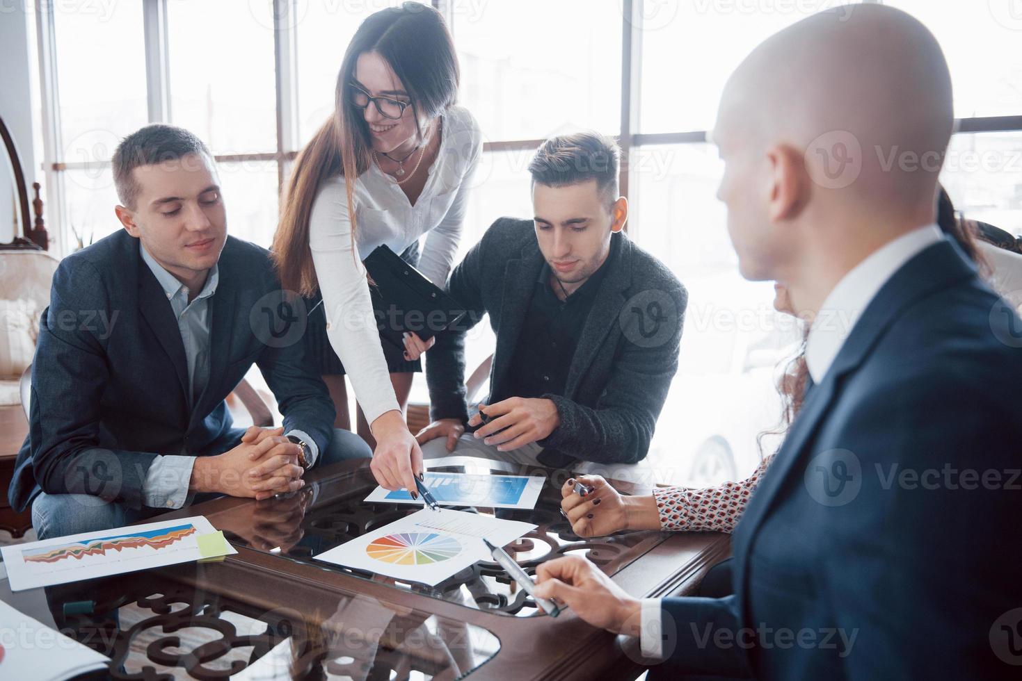 Young team of coworkers making great business discussion in modern coworking office. Teamwork people concept photo