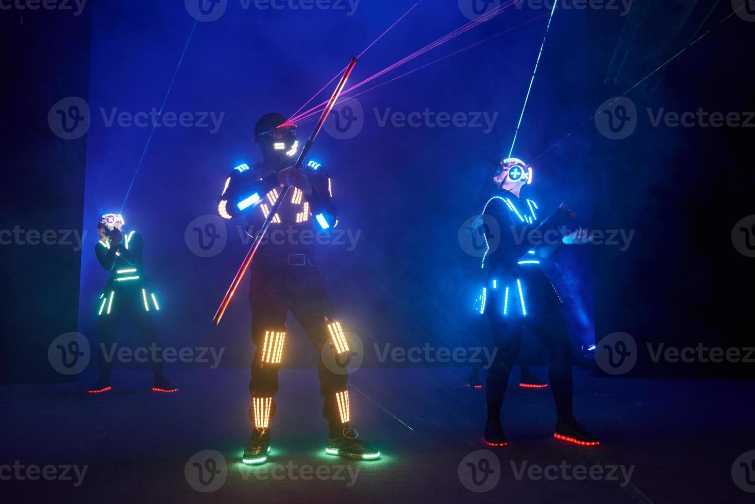 Laser show performance, dancers in led suits with LED lamp, very beautiful night club performance, party photo