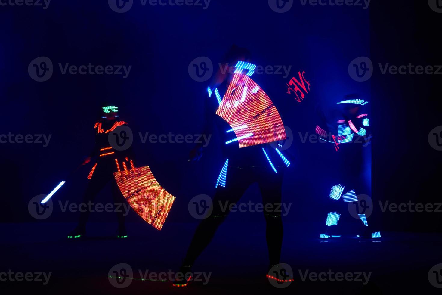 Laser show performance, dancers in led suits with LED lamp, very beautiful night club performance, party photo
