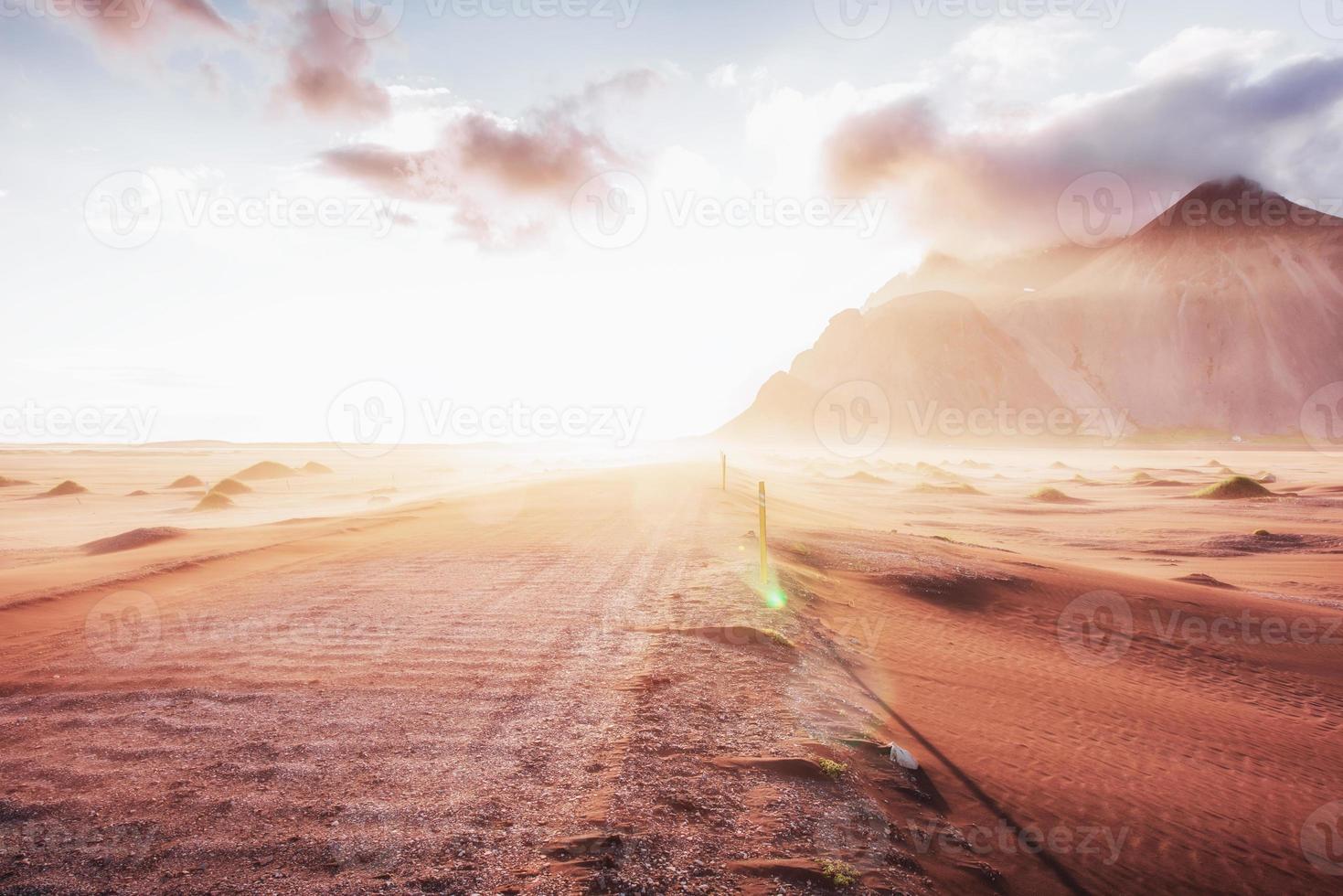 fantástica puesta de sol de las montañas y dunas de arena de lava volcánica a la playa en stokksness. el concepto de un día caluroso y un desierto. foto