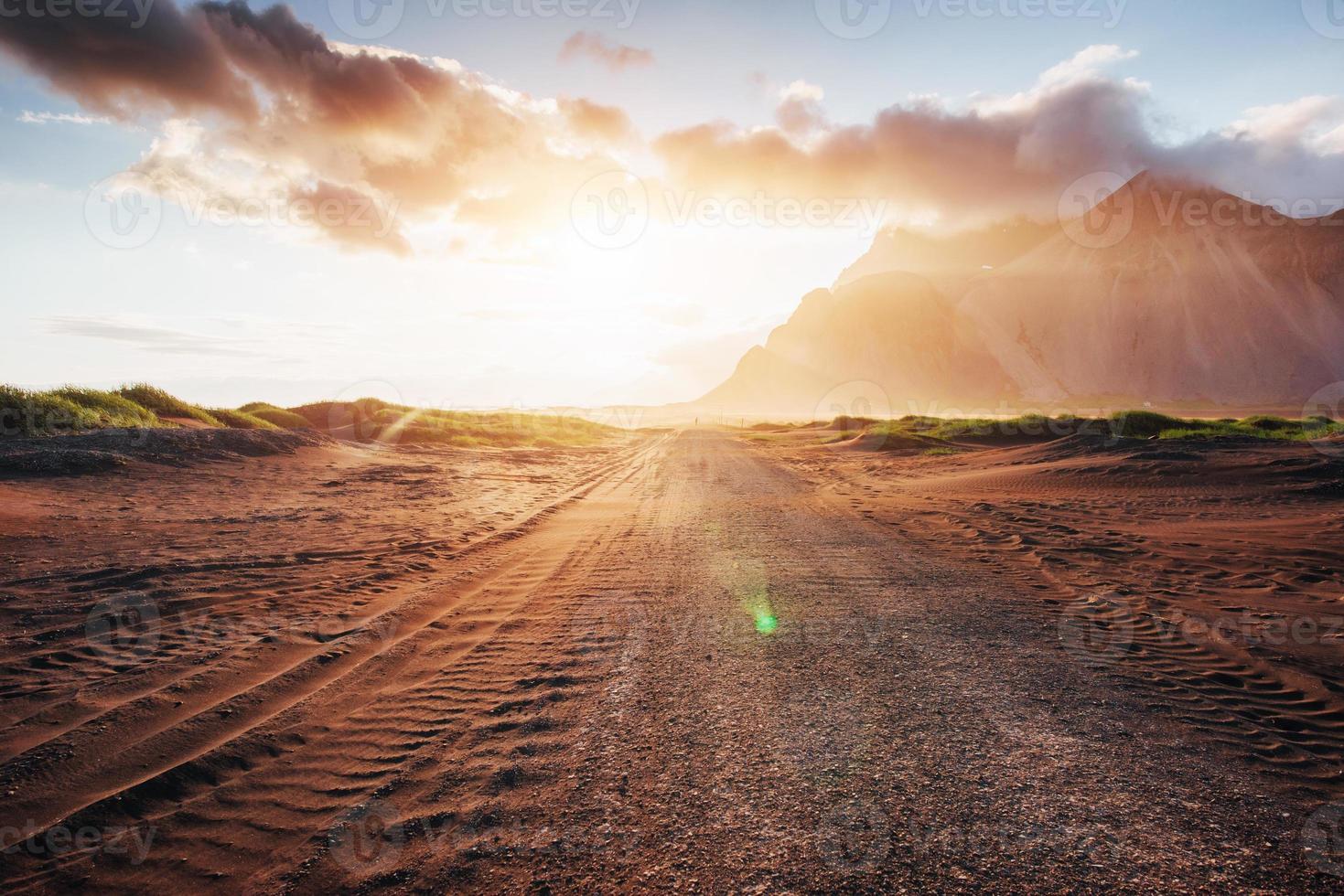 fantástica puesta de sol de las montañas y dunas de arena de lava volcánica a la playa en stokksness. el concepto de un día caluroso y un desierto. foto