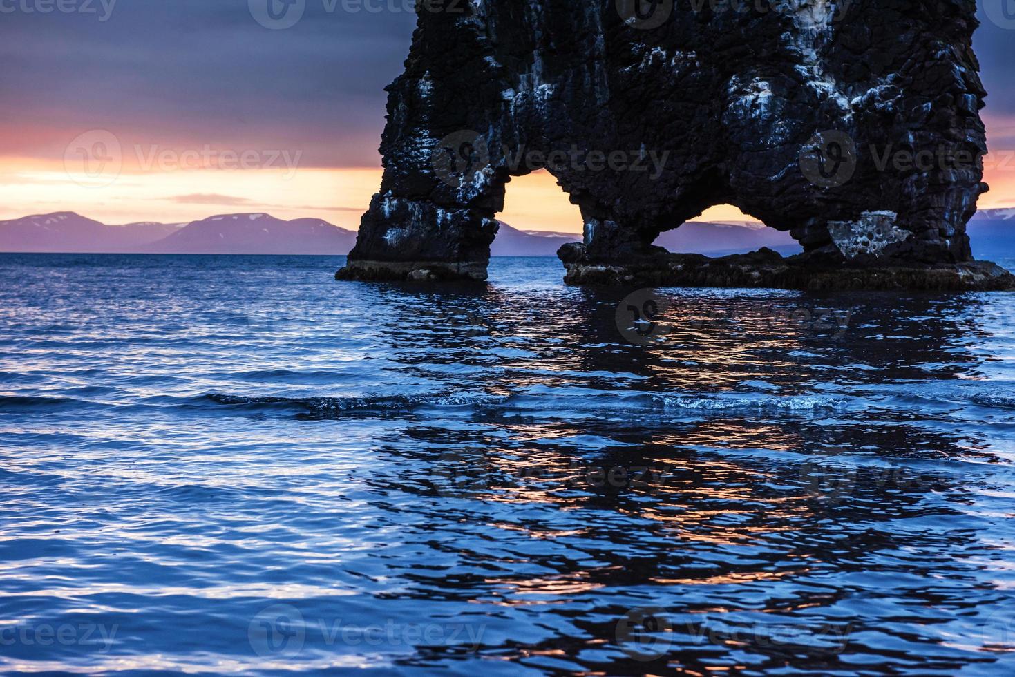 Hvitserkur is a spectacular rock in the sea on the Northern coast of Iceland. Legends say it is a petrified troll. On this photo Hvitserkur reflects in the sea water after the midnight sunset