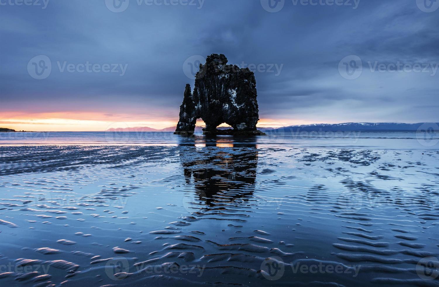 Hvitserkur is a spectacular rock in the sea on the Northern coast of Iceland. Legends say it is a petrified troll. On this photo Hvitserkur reflects in the sea water after the midnight sunset